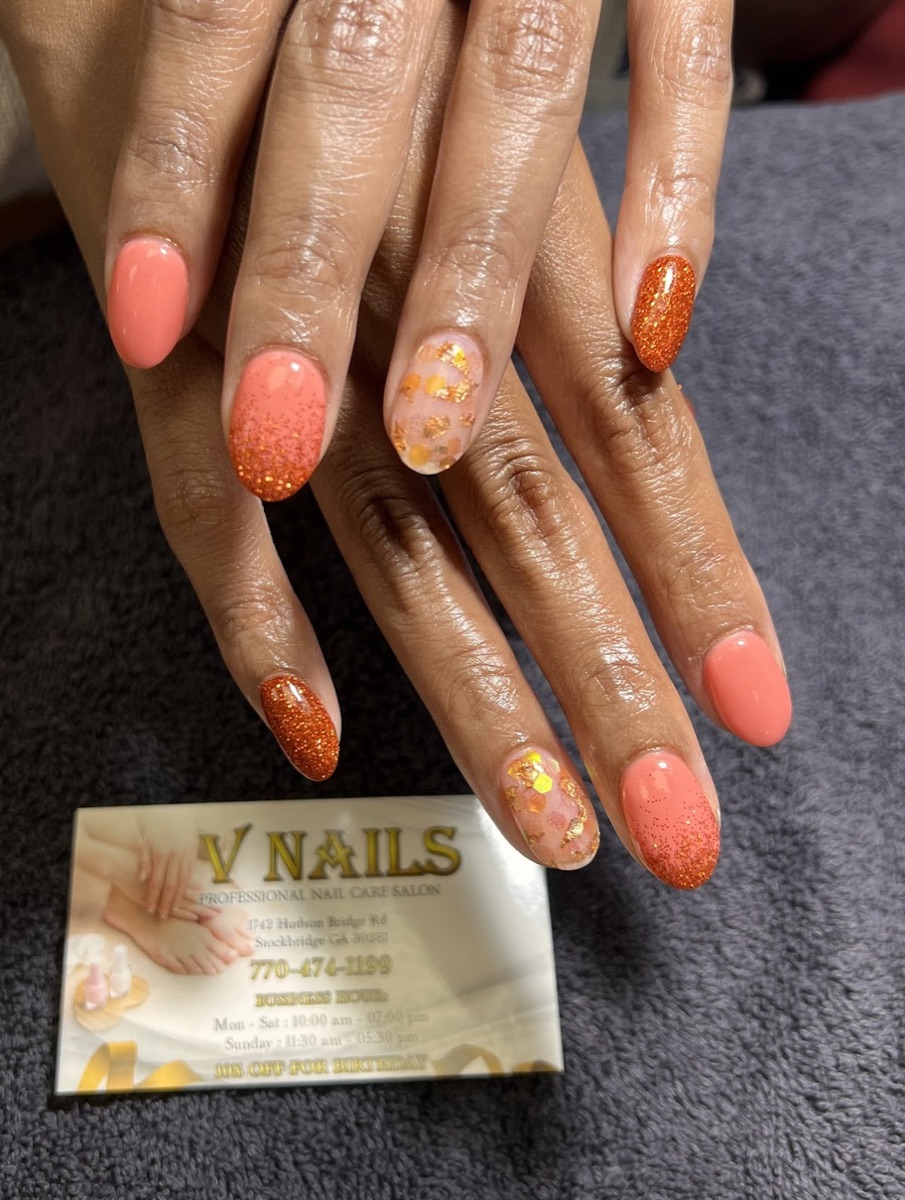 Coral and orange glitter nails with gold-flake accent