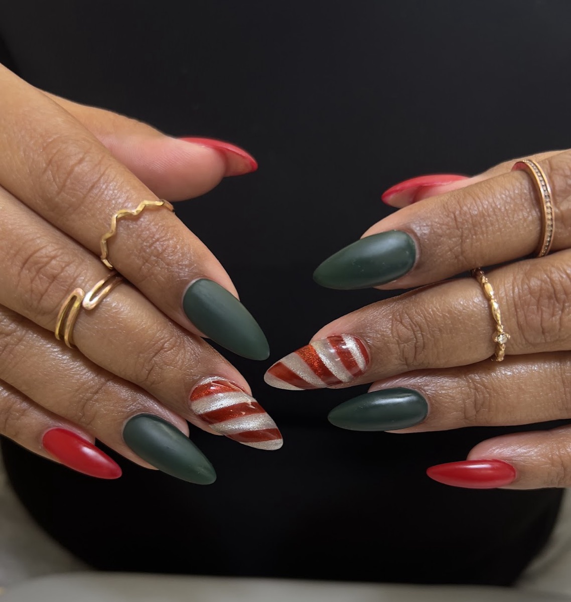 Deep green almond nails with candy-cane stripe accent
