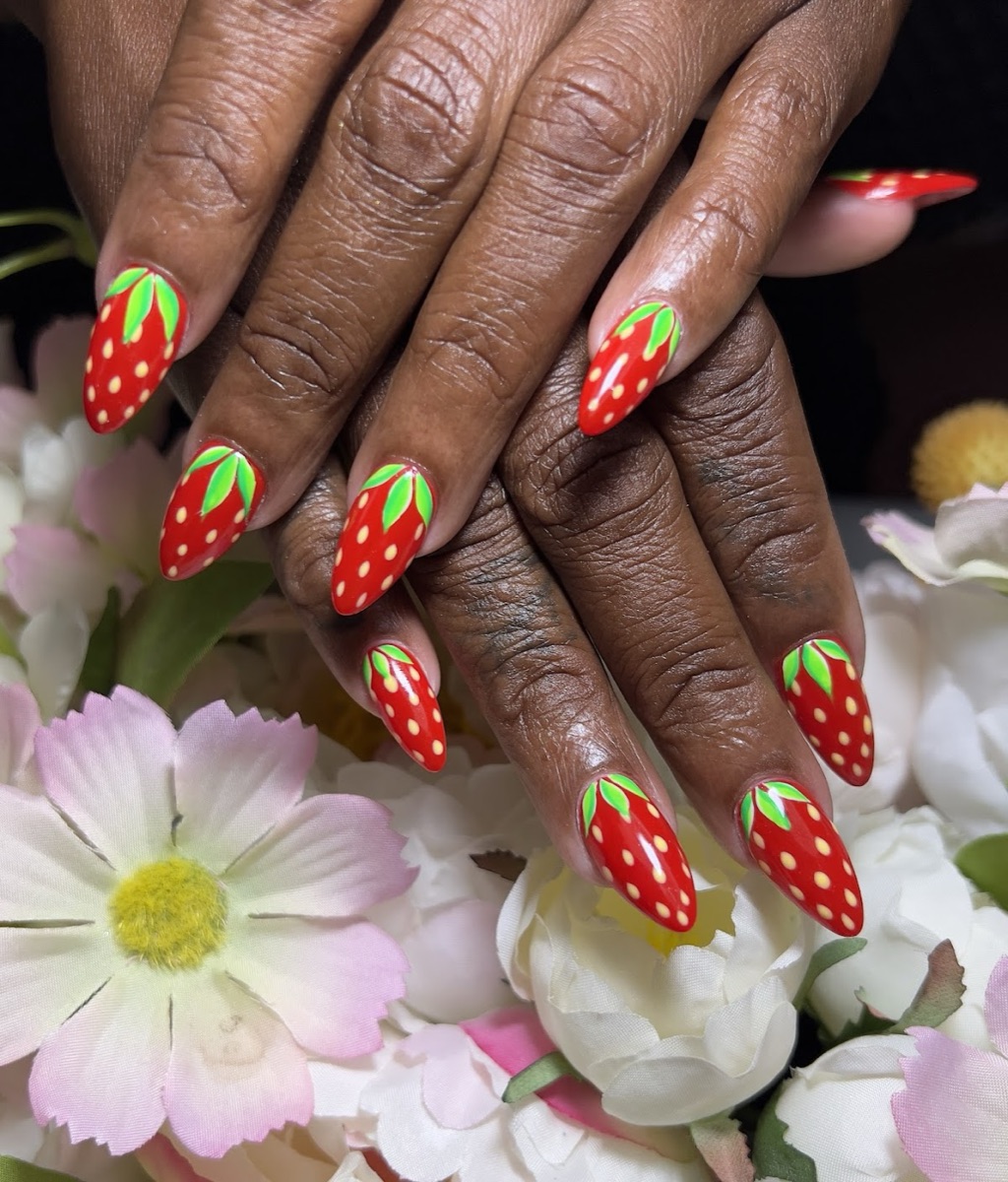Playful red strawberry nail art on almond nails