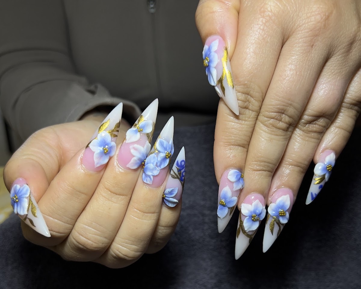Hand-painted blue floral nail art with gold detailing on stiletto nails at V Nails in Stockbridge, GA